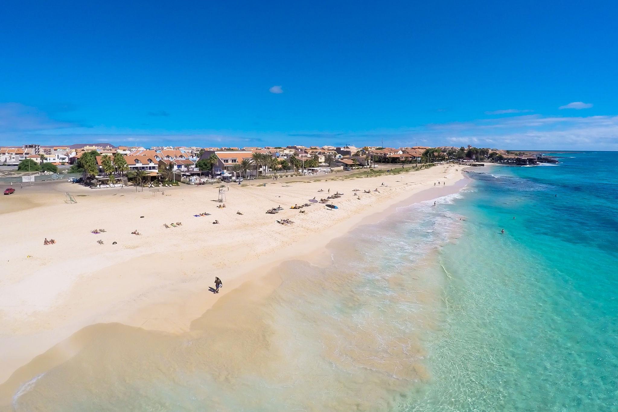 Sun loungers on a white-sand Sal beach beside turquoise water