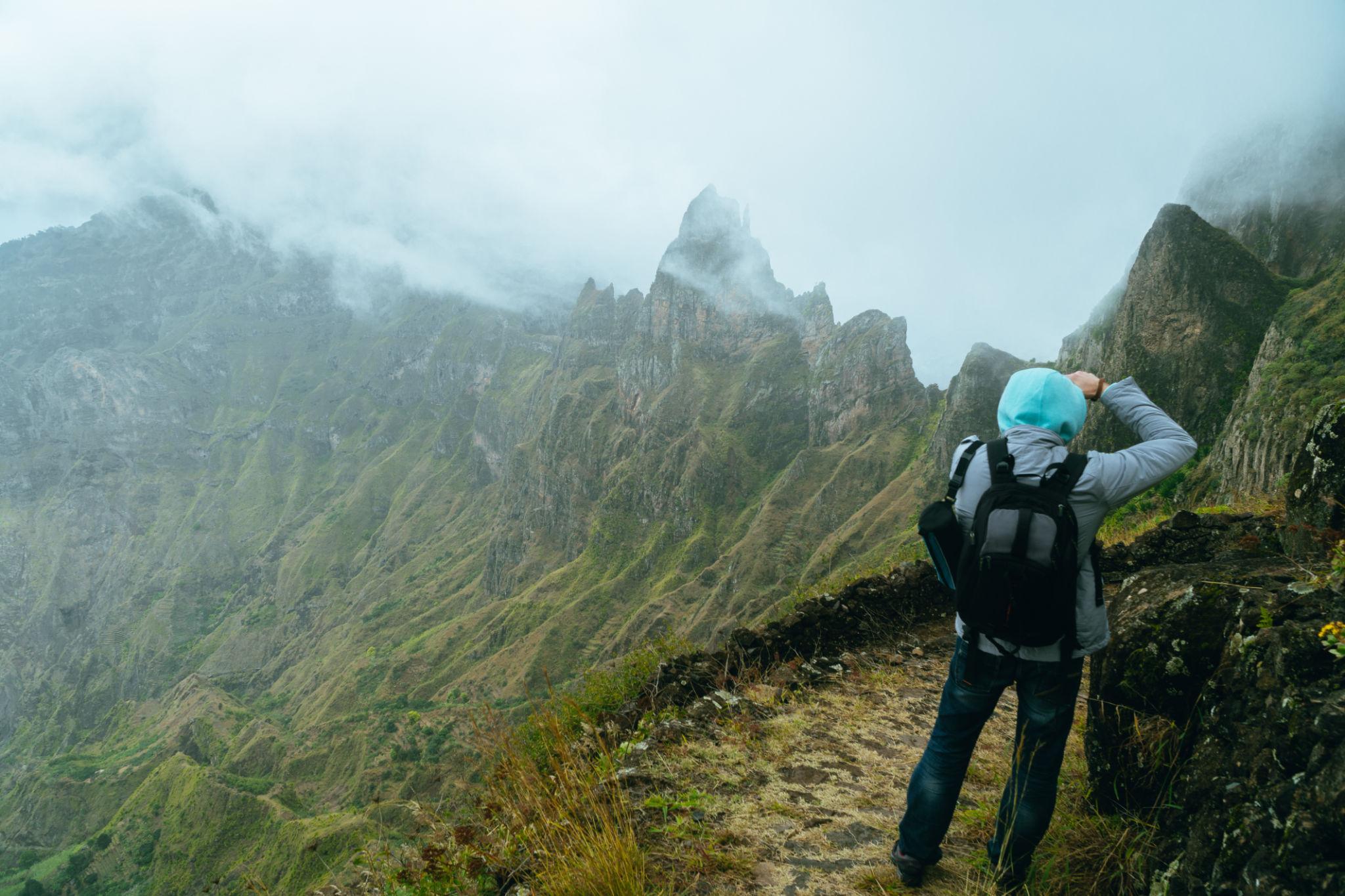 Traveller overlooking misty mountain peaks in Santo Antão, Cape Verde