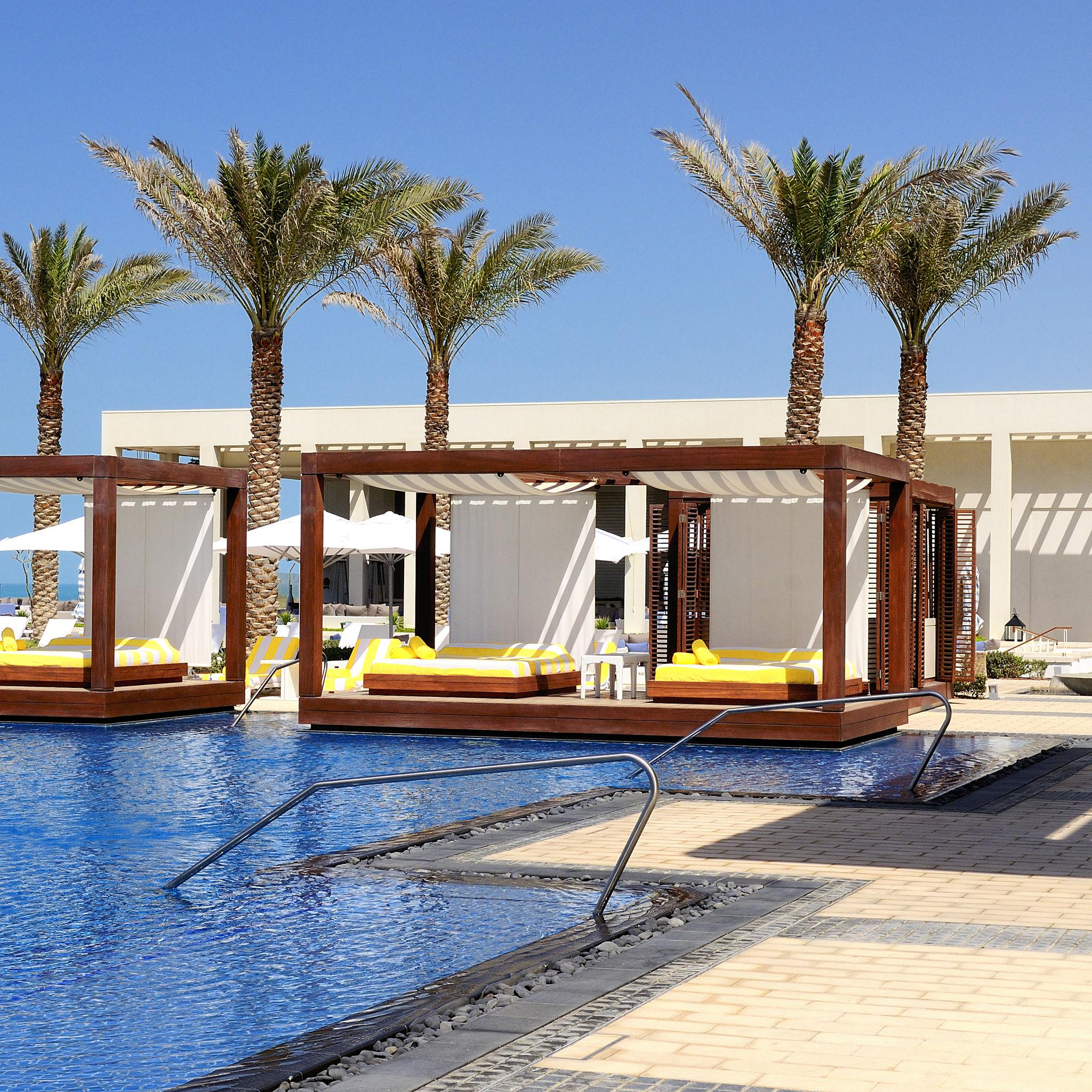Luxury pool cabanas beside palm trees in Cape Verde